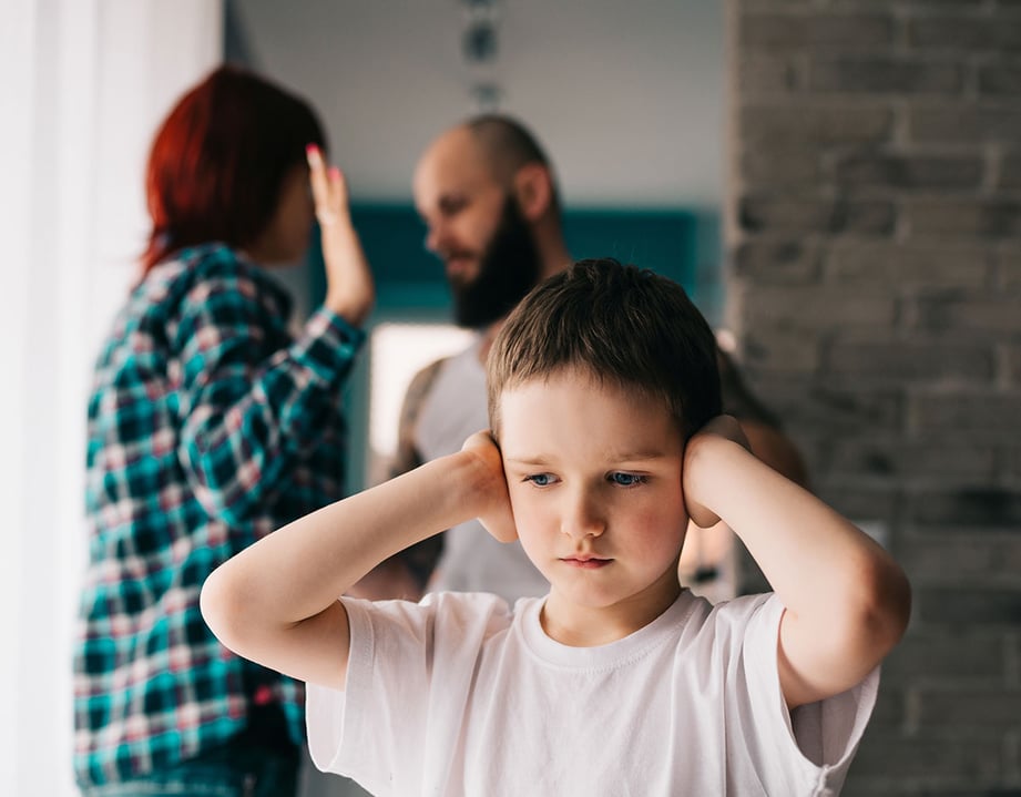 kid covering ears from parents fighting